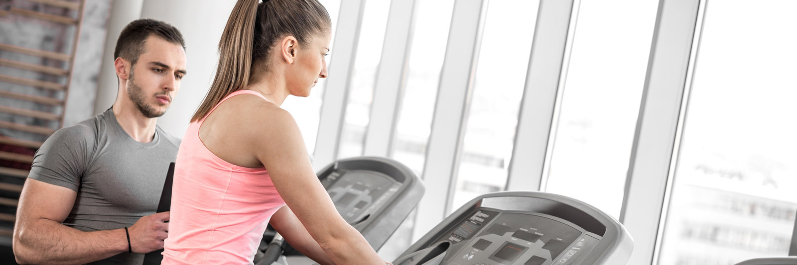 gym instructor talking to a woman on a treadmill