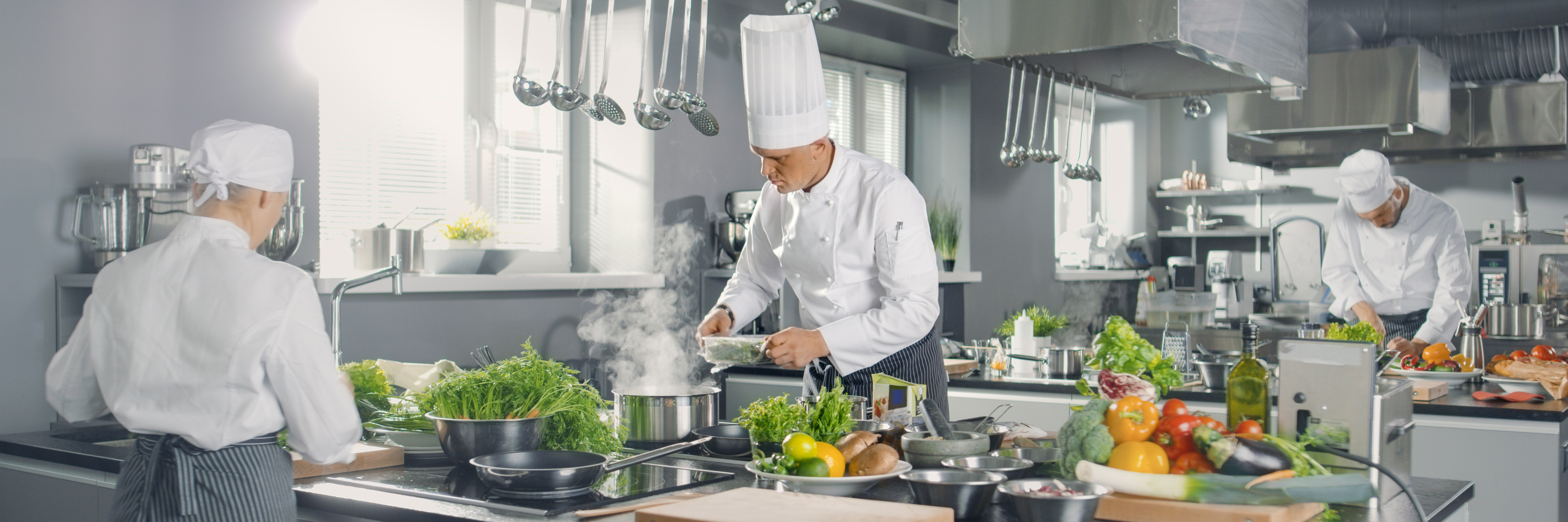 a kitchen with Production Chefs at their stations preparing their dishes