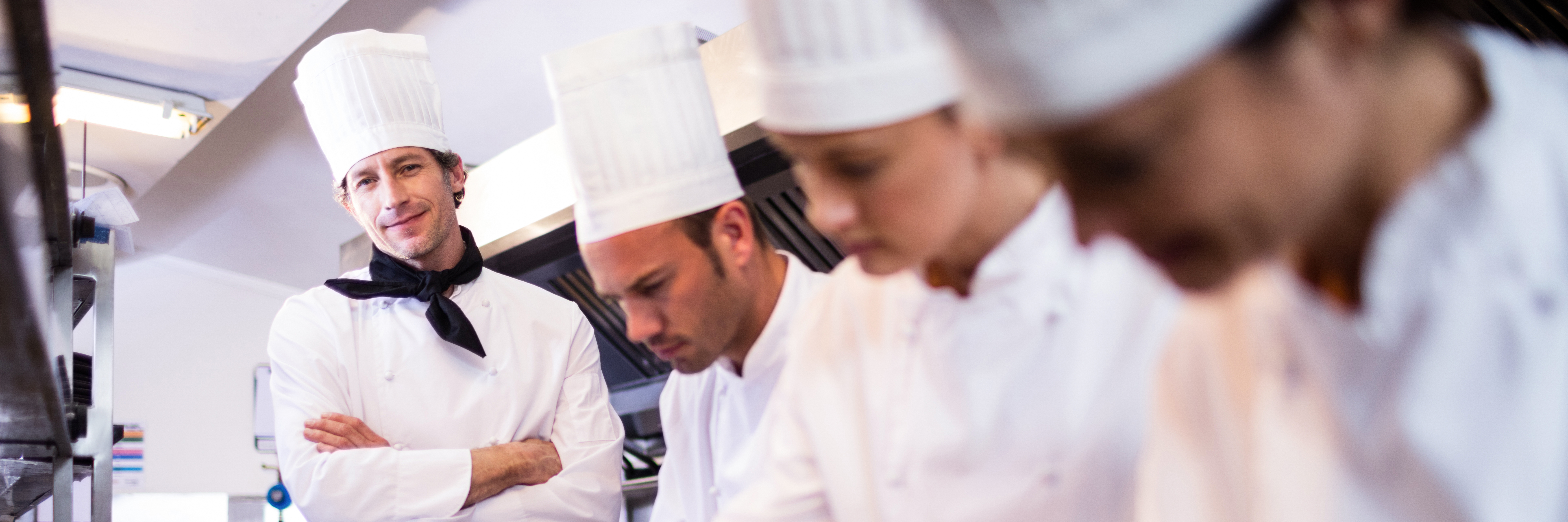 a kitchen with Senior Production Chefs at their stations preparing their dishes