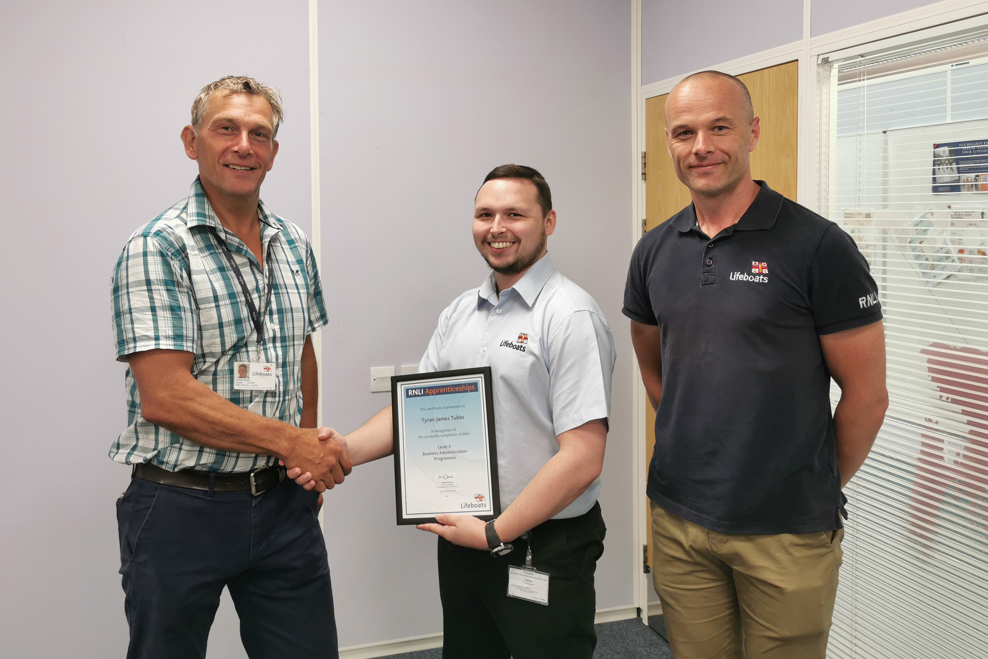 Image of Ty Tubbs recieving his apprenticeship certificate from head of department John Deas.